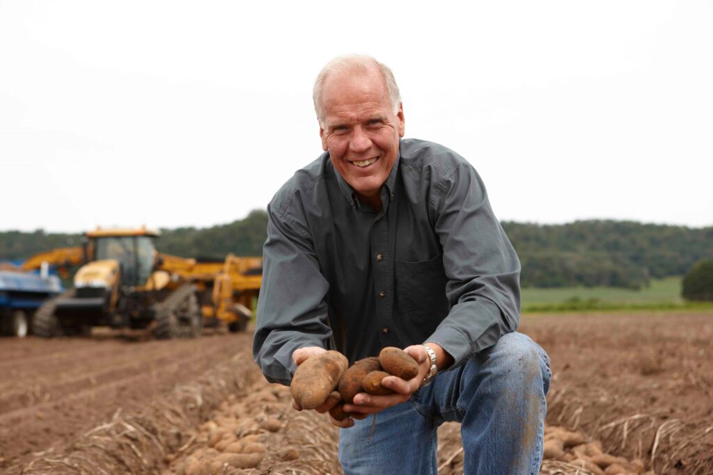 Larry Alsum holding freshly dug new crop WI Russet Potatoes