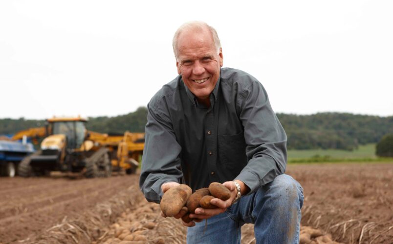 Larry Alsum holding freshly dug new crop WI Russet Potatoes